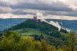Summer morning at sunrise with fog and historic chapel on the hill, hiking in the mountains.. Calvary over clouds in Banska Stiavnica, Slovakia. Summer landscape after a storm