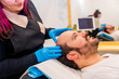 © unai - Dermatologist inspecting the bald man's head before a hair treatment