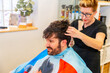 © unai - Hairdresser attaching a capillary prosthesis to a bald client