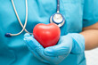 © amazing studio - Doctor holding a red heart in hospital ward, healthy strong medical concept.