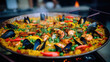 Seafood spanish paella close up with mussels, shrimp, vegetables, herbs in large pan