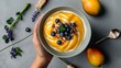 Homemade Healthy breakfast bowl with mango, blueberry and granola on grey background