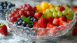 resh fruits in a glass bowl, including red grapes, green grapes, sliced strawberries, whole strawberries, blueberries, and mango chunks