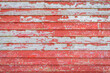 rustic wooden background of a barn or old house wall - planks of weathered pine red painted wood