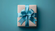 Elegant Gift Wrapped in Cream Paper with a Teal Ribbon on a Teal Background