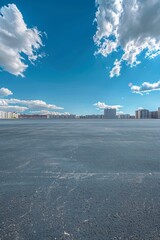 Poster - An empty parking lot with a clear blue sky and white clouds