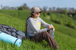 Young hiking woman taking a rest at green hill for rehydration