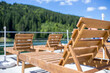 Rows of chaise-lounges at mountain resort near the lake at sunny day