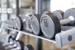 A row of dumbbells on steel rack in fitness gym.