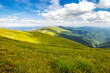 mountainous rolling landscape in summer. alpine meadows of borzhava ridge of ukrainian carpathian mountains in dappled light under a blue sky with fluffy clouds. wonderful place to hike for beginners