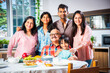 © StockImageFactory - Happy Indian asian family having lunch at home and posing for photo