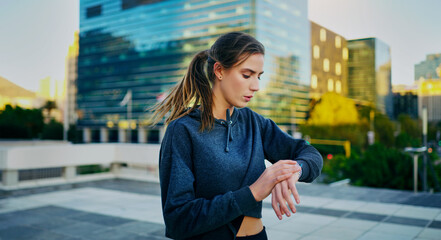 Poster - Woman, city and workout with break or time with pause, exercise and fitness for wellness. Female athlete, urban and stop for rest with watch, training or running with breathe for health in outdoor