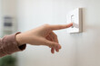 Save energy concept, Close-up finger of people turning off the electrical light switch on the wall before leaving home for security safety and save electricity bills expenses.