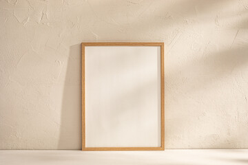 Wall Mural - Blank Canvas in Wooden Frame Against Textured Wall in Soft Light.