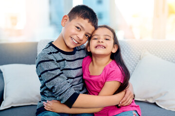 Canvas Print - Siblings, hug and portrait of kids in home on sofa to relax with care or support of happy family. Girl, brother or children embrace with love, kindness or friends on holiday and vacation in Mexico