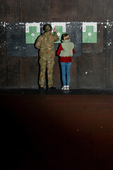 a professional shooting range military trainer and a girl check the target for hits