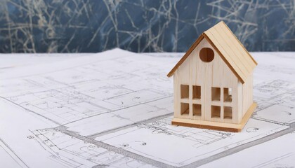 wooden house model stands on the drawings