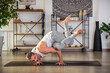 Fit man performing Crow pose on yoga mat at home