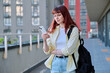 Young female using smartphone, modern city background