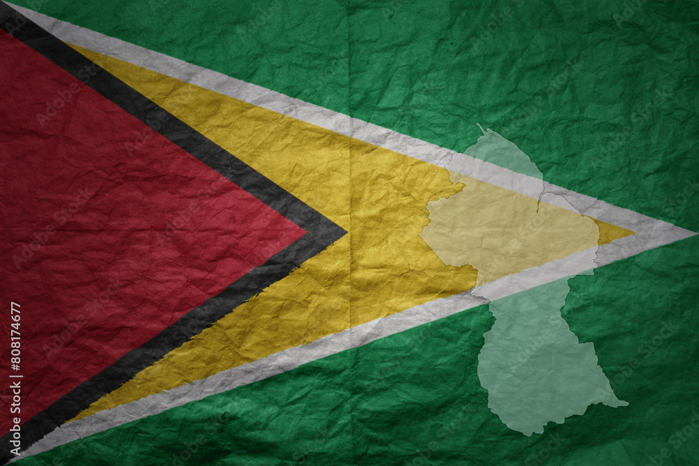 big national flag and map of guyana on a grunge old paper texture ...
