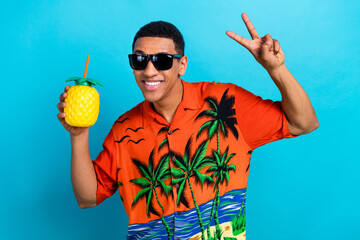 Wall Mural - Photo of cool funky guy dressed print shirt enjoying pineapple juice showing v-sign isolated blue color background