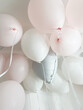 Pastel helium balloons hang from the ceiling in the room, holiday atmosphere