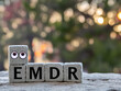 Emdr therapy, letters emdr written on gray stone cube blocks, blurred background. Eye Movement Desensitization and Reprocessing Psychotherapy Treatment concept. 