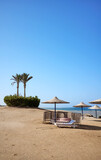 Fototapeta Mosty linowy / wiszący - Beautiful sandy beach with sun loungers and umbrellas, Marsa Alam region, Egypt