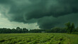 Approaching Storm. a dark and ominous storm cloud descending over a green field with rain pouring down.