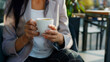 A woman is holding a cup of coffee in her hands.
