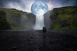 Backpacker in front of immense waterfall with a full moon