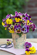 Blumenstrauß mit gelb und lila Hornveilchen und Stiefmütterchen in vintage Vase