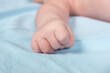 Close up view of newborn baby hand on a bed.