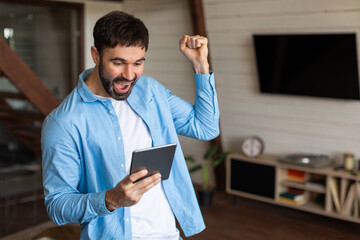 Aufkleber - A man wearing a blue jacket is seen holding a tablet device in his hands. The man appears focused on the tablet screen as he interacts with the device.