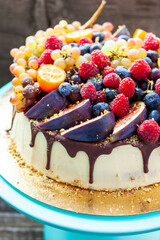Wall Mural - Delicious cheesecake with melted chocolate, apples, strawberries, blueberries, peaches, raspberries, blueberries, figs and grape on the top