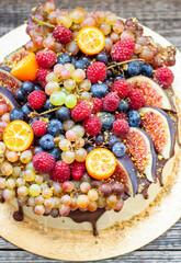 Wall Mural - Delicious cheesecake with melted chocolate, apples, strawberries, blueberries, peaches, raspberries, blueberries, figs and grape on the top
