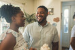 Joyous moment as a young African American couple celebrates with friends, sharing laughter and cake in a cozy home setting.