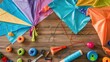Various types of kites made of textile materials in orange, red, and electric blue colors are displayed on the table. They feature different patterns, triangles, lines, and artistic paint designs