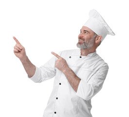 Wall Mural - Happy chef in uniform pointing at something on white background