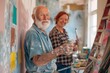 A cheerful senior male artist, with a full beard and twinkling eyes, confidently applies paint to a canvas. His female assistant, with red hair and a plaid shirt, stands behind him. 