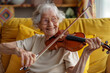 A delightful elderly woman with white hair and round glasses sits on a yellow sofa, playing the violin with a radiant smile.