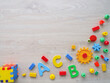 A colorful assortment of building blocks and letters, including are scattered across a wooden surface