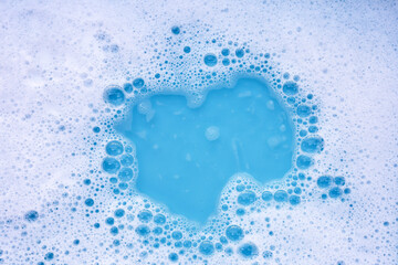 Wall Mural - Detergent foam bubble on water. Blue background, Soap sud