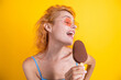 Happy young woman with delicious ice cream in waffle cone on yellow. Woman with a cornet ice cream. Delicious gelato in waffle cone in summer. Girl eating ice cream in summer. Refreshing ice cream