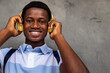 Happy teen African American boy looking at camera wearing headphones. Copy space.