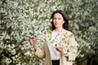 Woman allergic enjoying after treatment from seasonal allergy at spring. Portrait of happy young woman in front of blooming tree at springtime. Spring allergy concept.