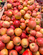 Ripe red apples on a counter in a market as a background. Texture