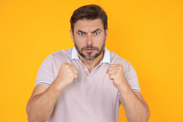 Portrait of Angry man screaming. Portrait of young angry man isolated on yellow background. Angry male face. Guy with nervous crisis. Negative human emotions facial expression feelings attitude.