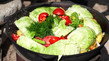 Poster - A person is adding tomatoes to a pot of vegetables