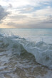 A small wave crashes ashore on a Caribbean island.